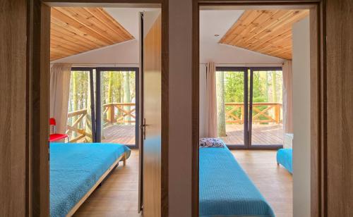 zwei Betten in einem Zimmer mit zwei Fenstern in der Unterkunft Nova Mazury in Święta Lipka
