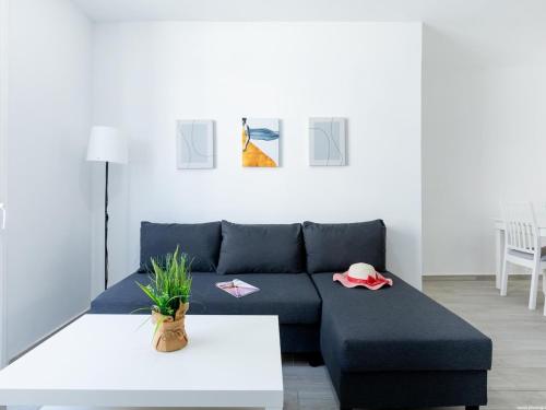 a living room with a blue couch and a table at Atico Vega Penthouse in Adeje