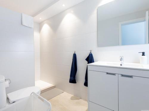 a white bathroom with a sink and a toilet at Atico Vega Penthouse in Adeje
