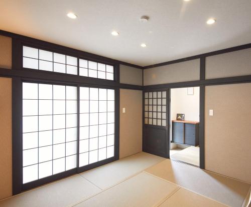 a large room with large windows and doors at リノベーションされた一軒家で富士山と自然 BBQを満喫 villa voyage in Azagawa