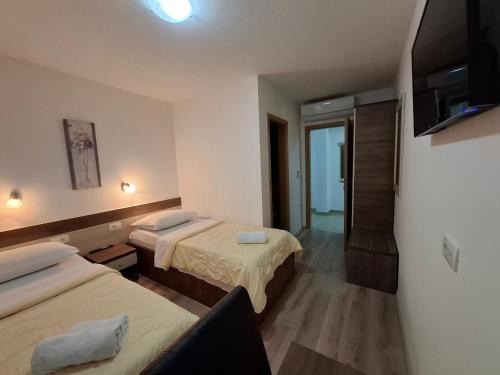 a hotel room with two beds and a television at Villa Gaga in Međugorje