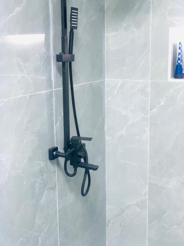 a hair dryer hanging on the wall of a bathroom at Rooms & Suites Western Dhafra Housing in Ghayathi