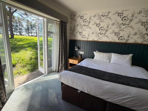 a bedroom with a bed and a large window at St Leonards Hotel by Greene King Inns in Saint Leonards