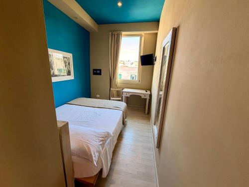 a small room with two beds and a window at White House in Trani