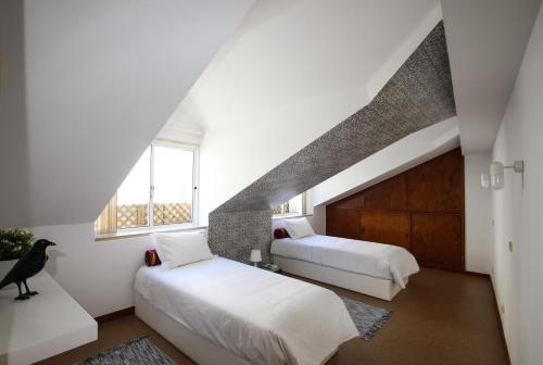 リスボンにあるBN GHouseの屋根裏のベッドルーム(ベッド2台、窓付)