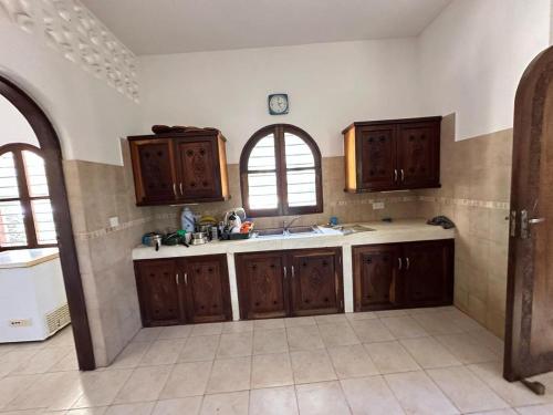 a kitchen with wooden cabinets and a sink and a window at Executive One bedroom with extra mattress 02 in Mombasa