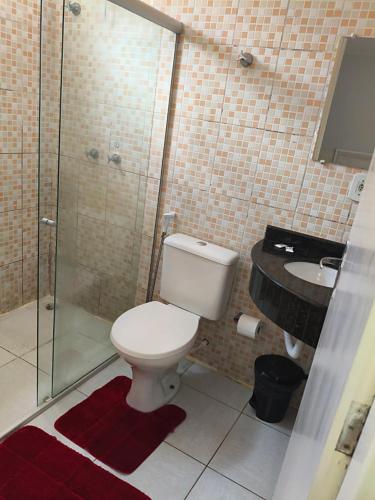 a bathroom with a toilet and a shower and a sink at Hotel Senna in Arapiraca