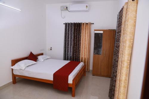 a bedroom with a bed in a room with a window at Rio Casa Homestay in Cochin