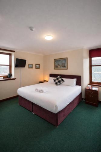 a bedroom with a large bed and a television at The Anchorage in Troon