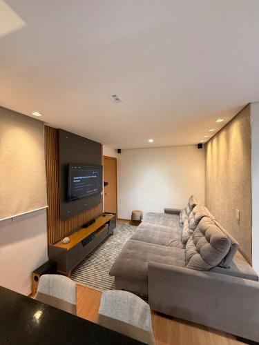a living room with a large bed and a flat screen tv at Belo Apartamento Com Piscina in Várzea Grande