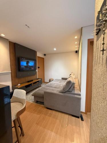 a bedroom with a bed and a flat screen tv at Belo Apartamento Com Piscina in Várzea Grande