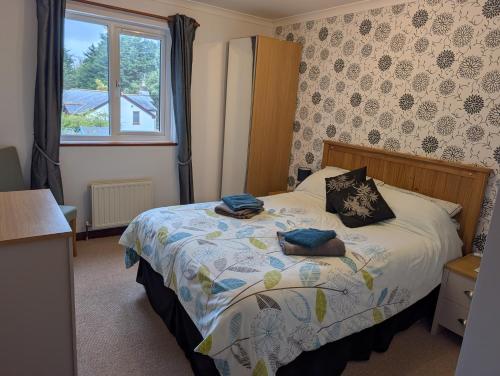a bedroom with a bed and a window at Near Eden Project apartment in Trethurgy