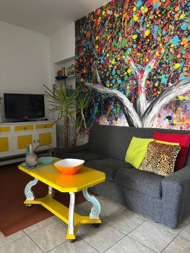 a living room with a couch and a table with a painting at L’Albero Colorato in Candelo