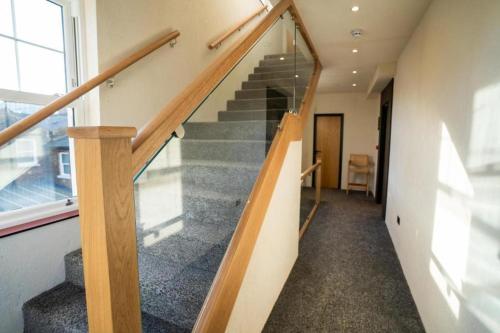 a staircase in a house with a glass railing at Roza Hotel in Enfield
