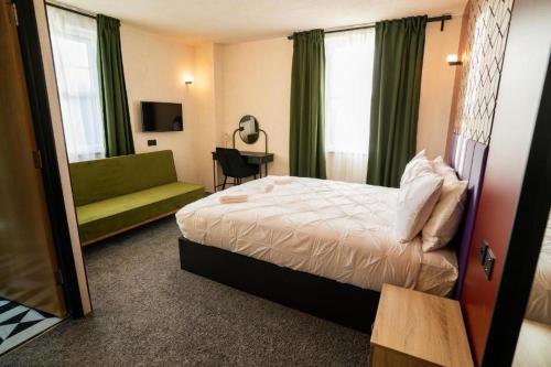 a hotel room with a bed and a green couch at Roza Hotel in Enfield