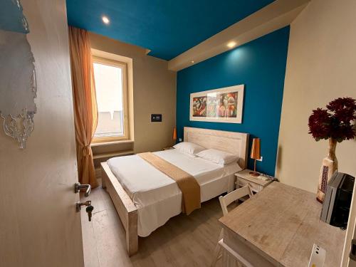 a bedroom with a bed and a blue wall at White House in Trani