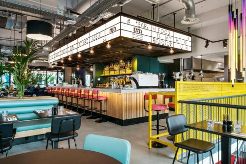 a restaurant with colorful chairs and a bar at The Social Hub Amsterdam West 4 star in Amsterdam