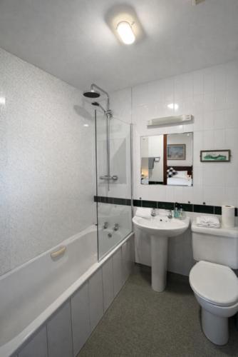 a bathroom with a toilet and a sink and a tub and a toilet at The Anchorage in Troon