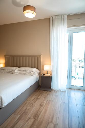 a bedroom with a bed and a large window at D'Stay in Bari