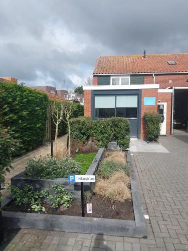 a house with a sign in front of a garden at 't Vakansie'uus in Serooskerke