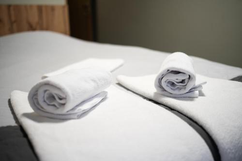 two towels on a bed with white sheets at Zielony Dworek in Kraśnik