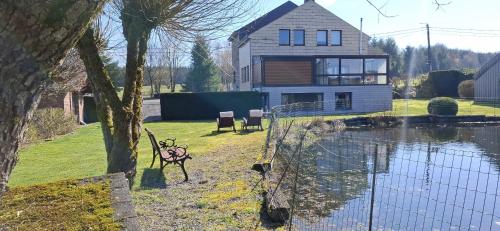 a house sitting next to a body of water at Bulle d'eau in Gouvy