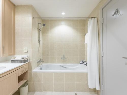a bathroom with a bath tub and a sink at the 'New York' Condo - 4BR Executive Burj Khalifa Suite in Dubai