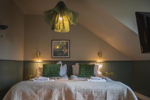 a bedroom with a large bed with green pillows at Västerhöjdsgården in Skövde