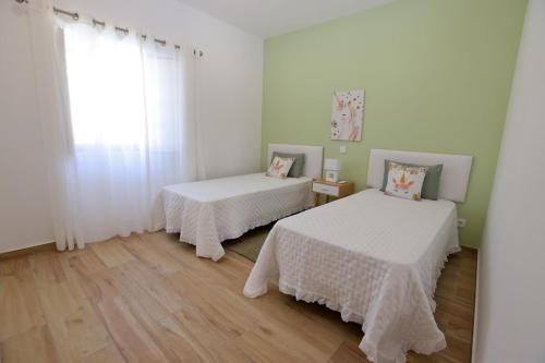 a room with two beds and a window at Casa Oliveira in Silves