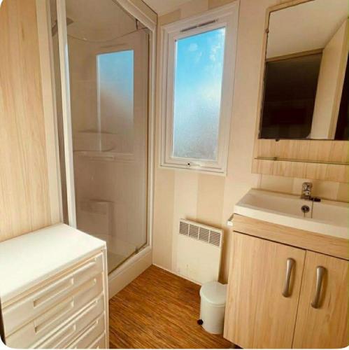 a small bathroom with a shower and a sink at Au Valras plage in Sérignan