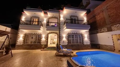 a villa with a swimming pool at night at Villa golden life apartments, new property with pool access in Luxor