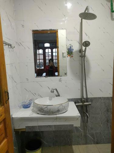 a person taking a picture of a sink in a bathroom at THANH XUAN Hotel in Sapa