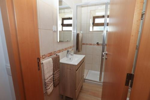 a bathroom with a sink and a mirror and a shower at Casa Oliveira in Silves