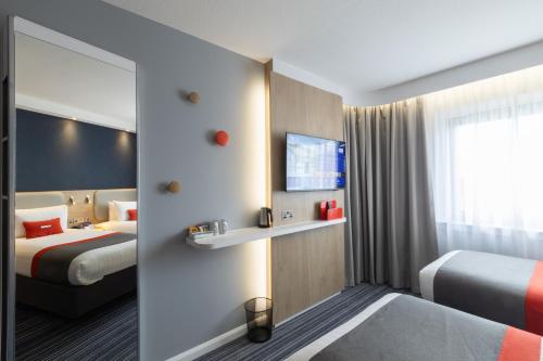 a hotel room with two beds and a tv at Holiday Inn Express London Croydon by IHG in Croydon