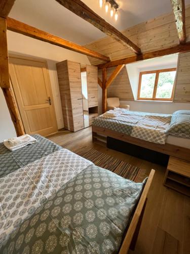 two beds in a room with wooden walls at Kuća za odmor Goranski mir in Mrkopalj