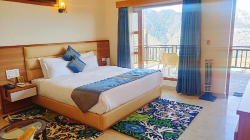 a bedroom with a bed and a balcony at Hotel Alpine Musk in Kanatal