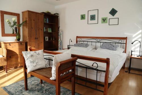 a bedroom with a bed and a chair in it at Ferienwohnung Zentral in Langenargen