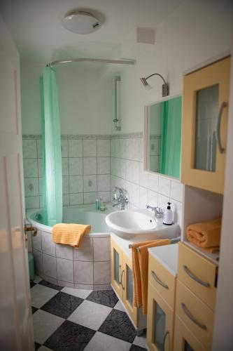 a bathroom with a tub and a sink and a shower at Ferienwohnung Zentral in Langenargen
