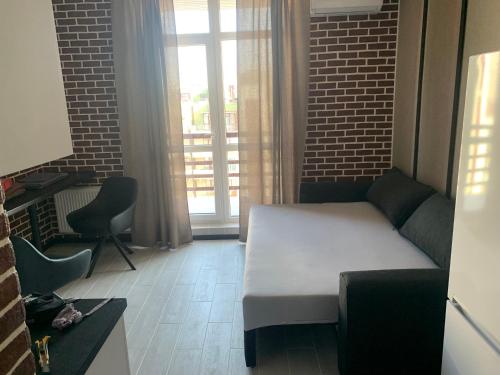 a room with a bed and a couch and a window at Стильна смарт-квартира in Odesa