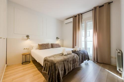a bedroom with a bed and a large window at Palau de la Musica Apartments in Barcelona