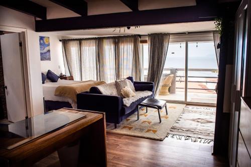 a bedroom with a bed and a living room with a view at Baja Beach House Pools, Beaches & Ocean View in San Antonio del Mar