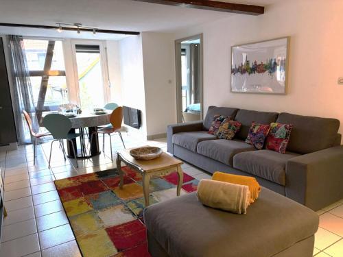 a living room with a couch and a table at L'Appart avec terrasse - centre historique in Barr