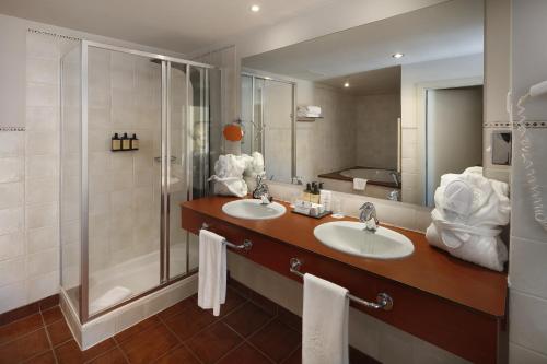 a bathroom with two sinks and a shower at Parador de Vielha Spa & Wellness in Vielha