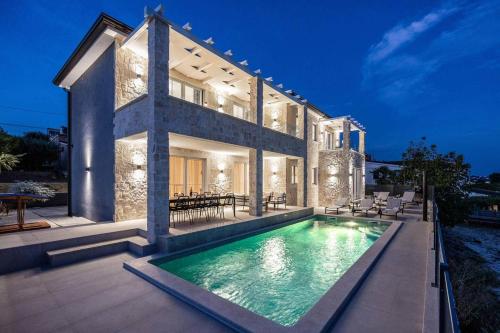 a house with a swimming pool in front of it at Villa Bella Vista with Pool and Seaview in Labinci