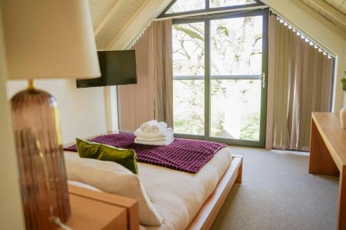 a hotel room with a bed with a large window at Oak Lodge in Knighton