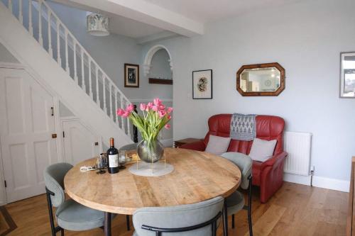 a dining room with a table with a vase of flowers at Totterdown's Fabulous House & Floral Garden in Bristol