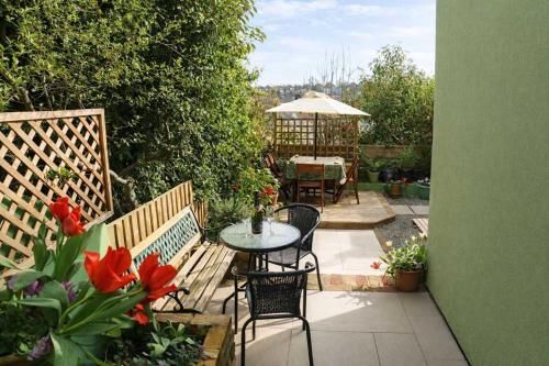 a patio with a table and chairs and an umbrella at Totterdown's Fabulous House & Floral Garden in Bristol