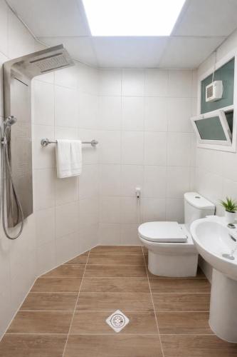 a white bathroom with a toilet and a sink at Sahara View Guest House Prime Location on the Dubai Sharjah Border in Sharjah