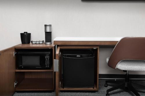 a desk with a microwave next to a desk with a chair at Courtyard by Marriott Portland Tigard in Tigard