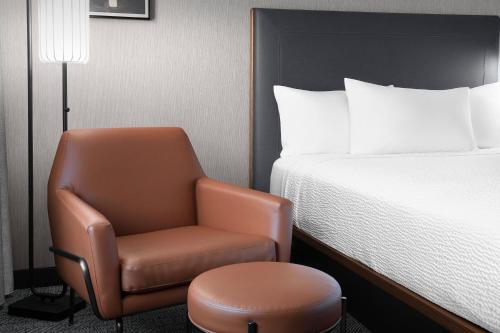 a room with a chair and a bed at Courtyard by Marriott Portland Tigard in Tigard